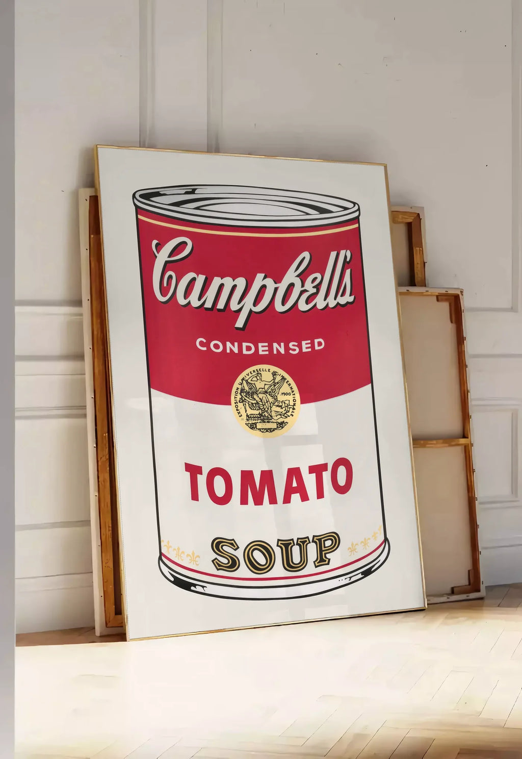 Tirage encadrable affiche cuisine soupe tomate, posee au sol dans une entree lumineuse, contre un mur a panneaux blancs, a cote de chassis en bois empiles