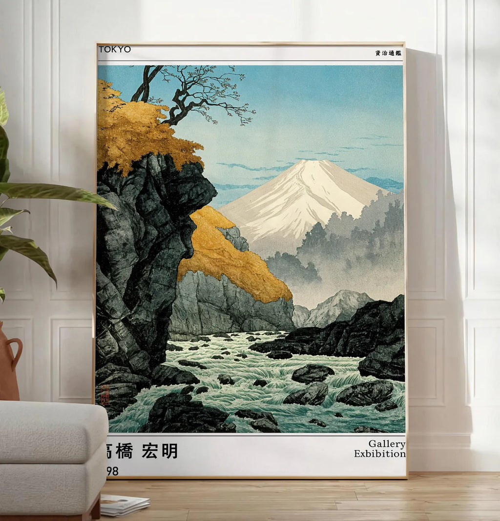 Reproduction affiche mont Fuji Takahashi Hiroaki, posee au sol dans un salon minimaliste clair, a cote d'un canape beige et d'une plante verte, sur un parquet clair