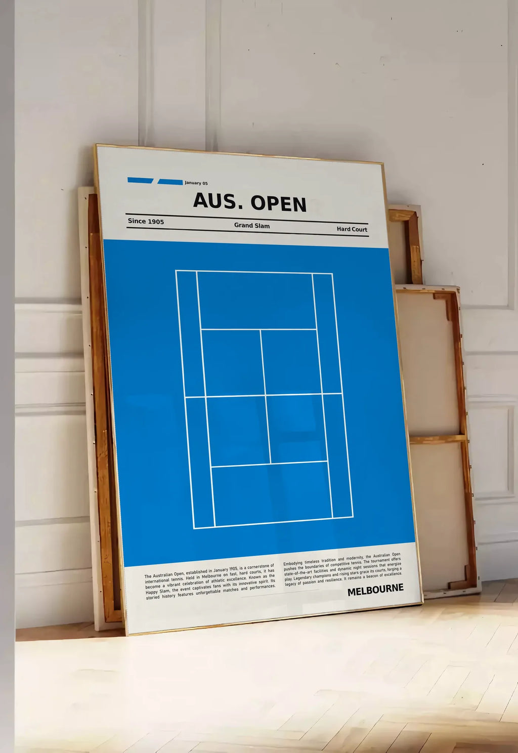 Tirage encadrable court de tennis stylisé, posee au sol dans une entree lumineuse, contre un mur a panneaux blancs, a cote de chassis en bois empiles
