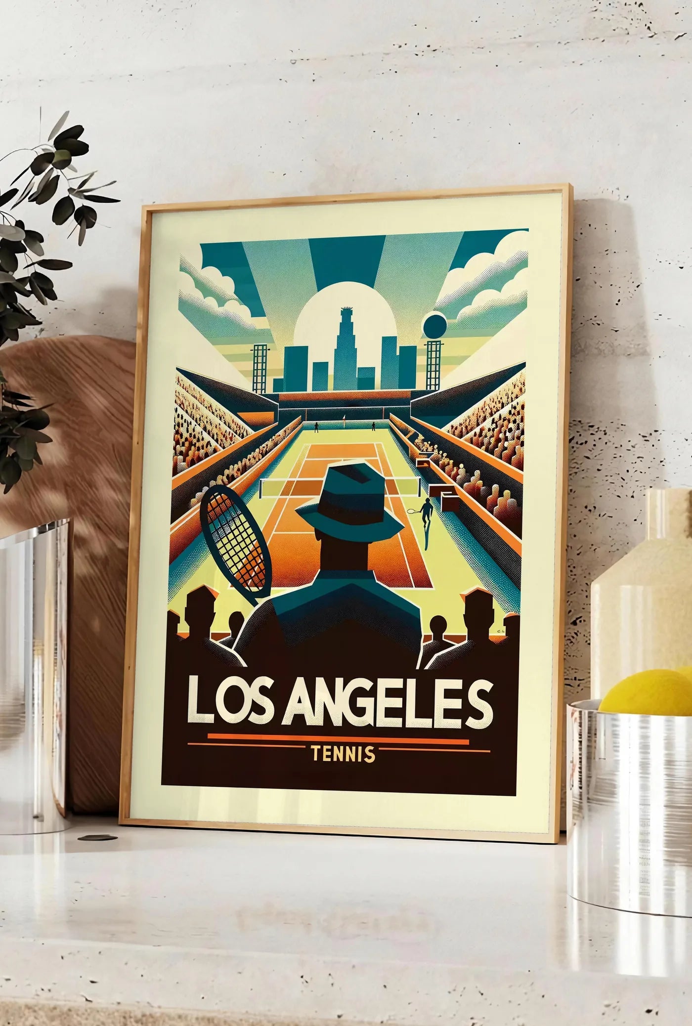 Affiche affiche tennis Los Angeles Art Deco, posee sur un plan de travail de cuisine en pierre claire, entre une branche d'eucalyptus en vase et un bocal de citrons