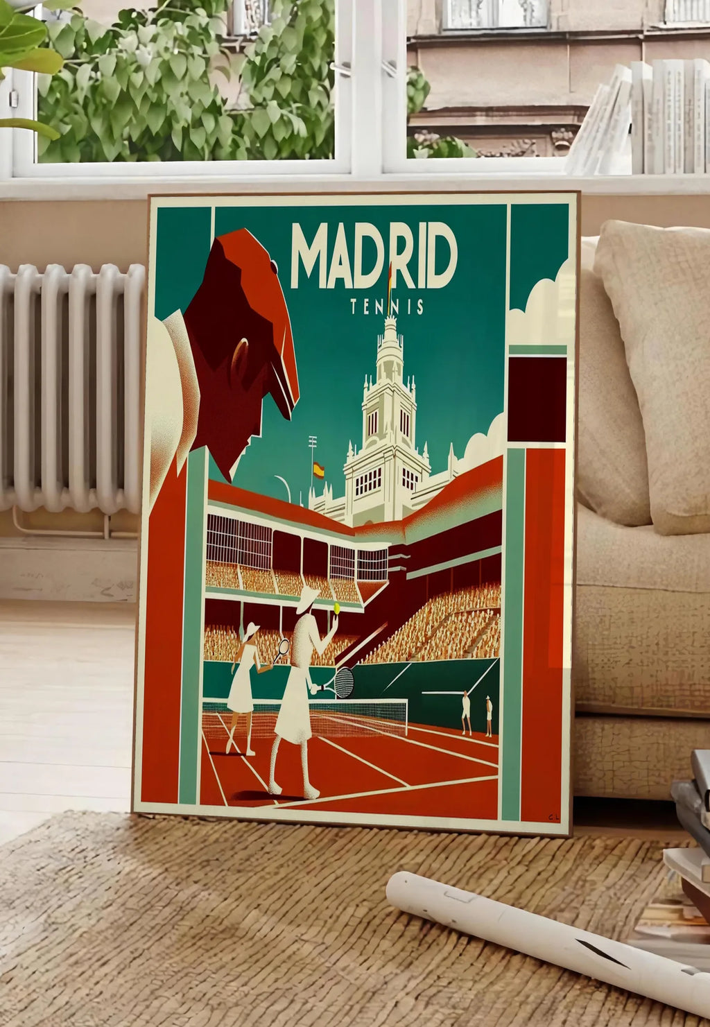 Poster affiche tennis Madrid art deco, posee au sol dans un salon parisien, devant une grande fenetre donnant sur un immeuble haussmannien, entre un ficus et un canape creme
