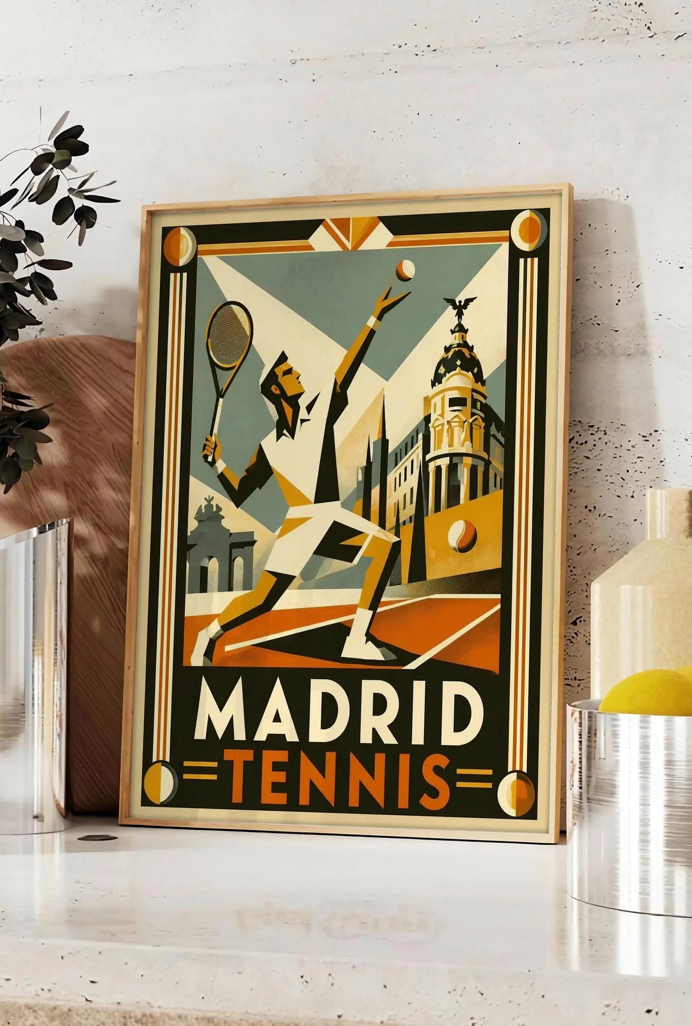 Affiche affiche tennis Madrid art deco, posee sur un plan de travail de cuisine en pierre claire, entre une branche d'eucalyptus en vase et un bocal de citrons