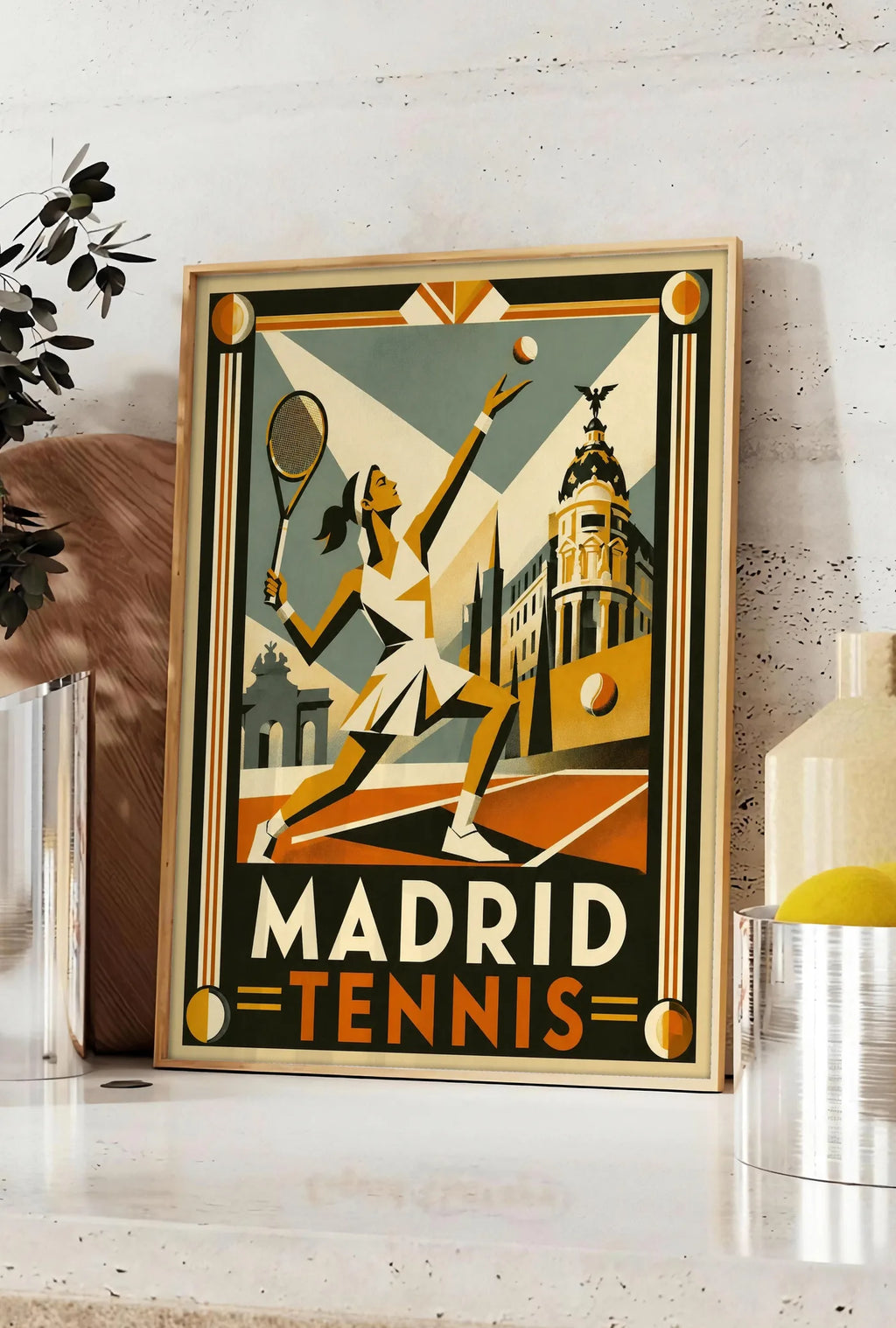 Affiche affiche tennis Madrid art deco, posee sur un plan de travail de cuisine en pierre claire, entre une branche d'eucalyptus en vase et un bocal de citrons