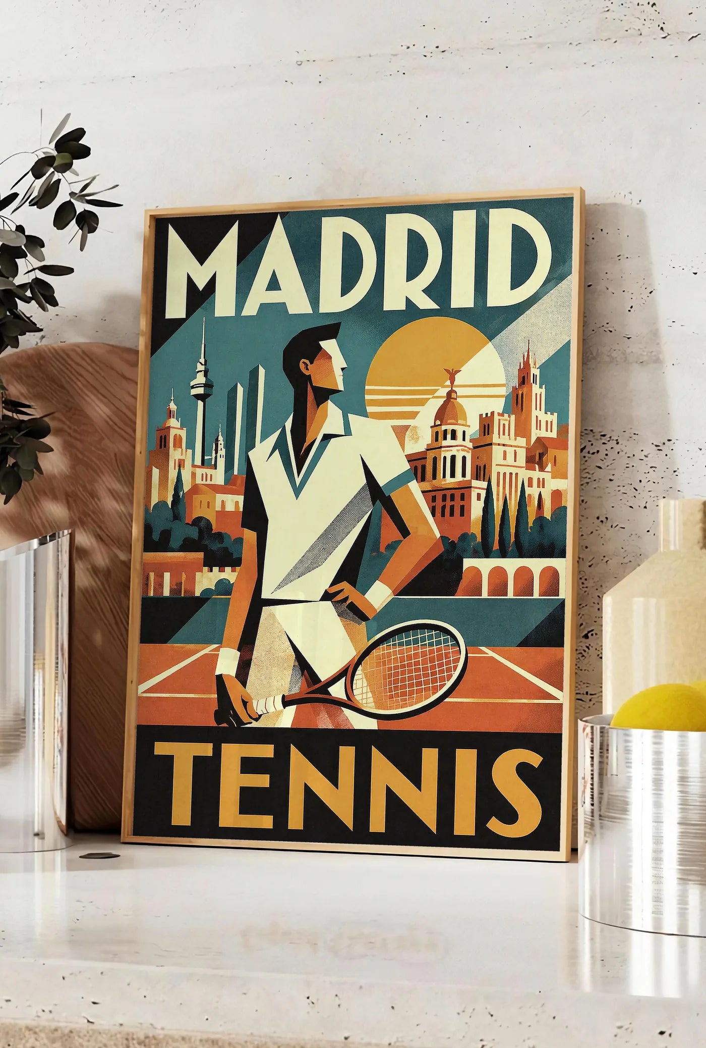 Affiche affiche tennis Madrid art deco, posee sur un plan de travail de cuisine en pierre claire, entre une branche d'eucalyptus en vase et un bocal de citrons