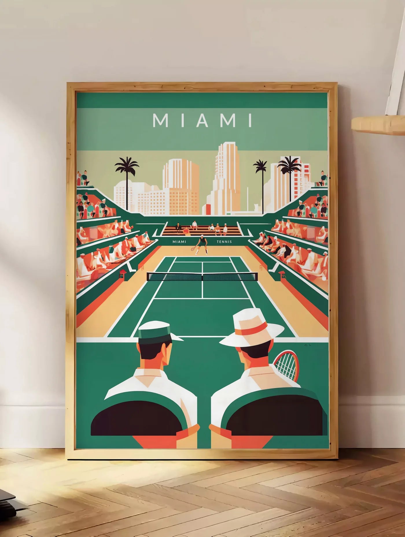 Estampe spectateurs et court de tennis vert, posee au sol dans un coin salon, sur un parquet a chevrons, pres d'une table d'appoint en chene chargee de livres