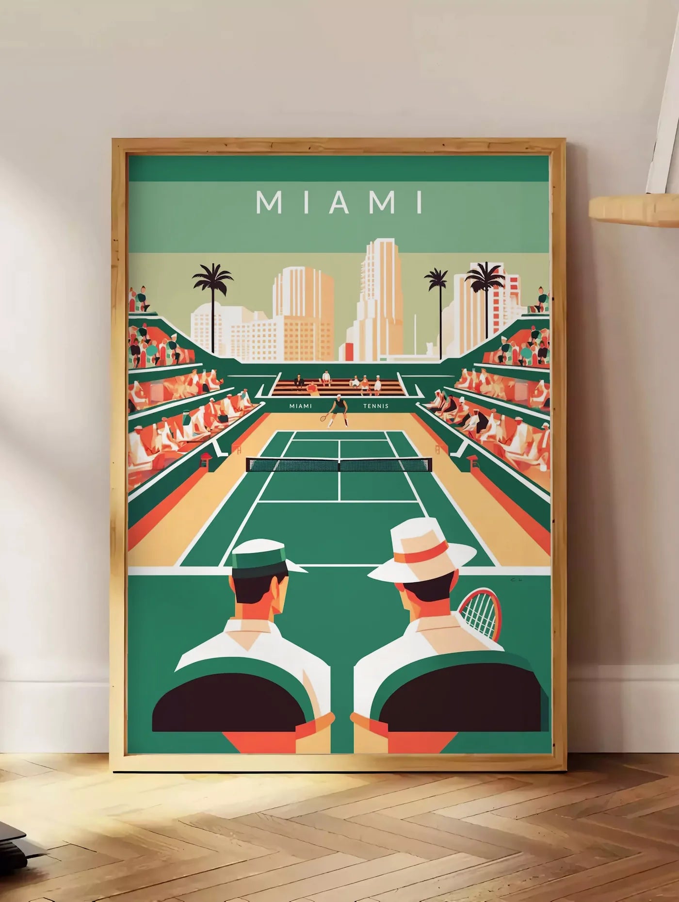 Estampe court de tennis vert et spectateurs, posee au sol dans un coin salon, sur un parquet a chevrons, pres d'une table d'appoint en chene chargee de livres