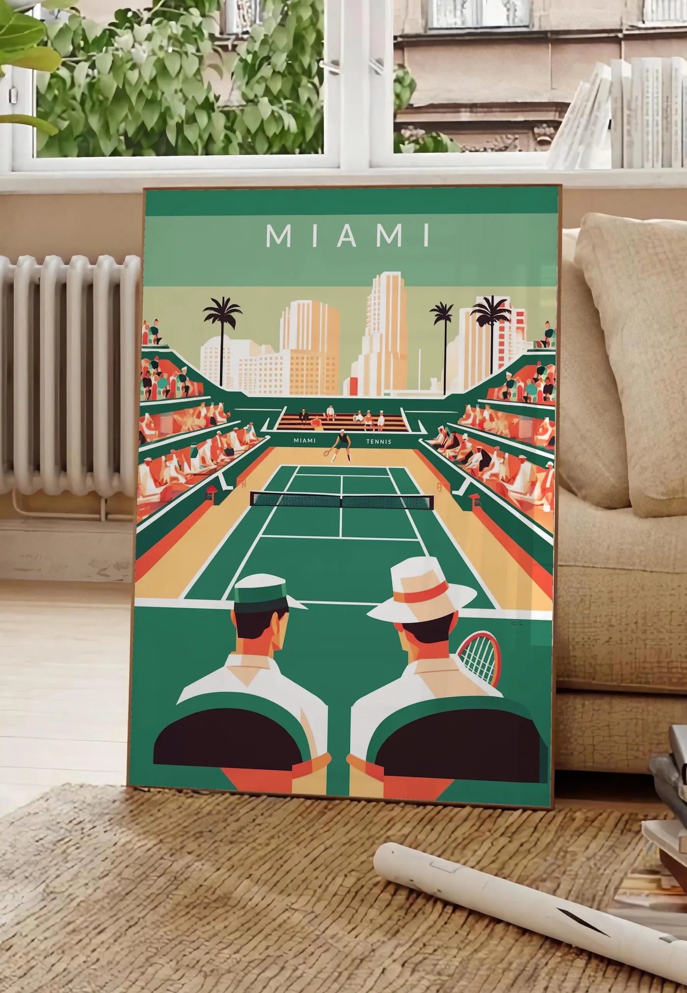 Poster court de tennis vert et spectateurs, posee au sol dans un salon parisien, devant une grande fenetre donnant sur un immeuble haussmannien, entre un ficus et un canape creme
