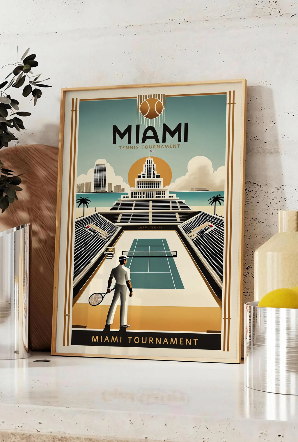 Affiche joueur de tennis devant un stade, posee sur un plan de travail de cuisine en pierre claire, entre une branche d'eucalyptus en vase et un bocal de citrons