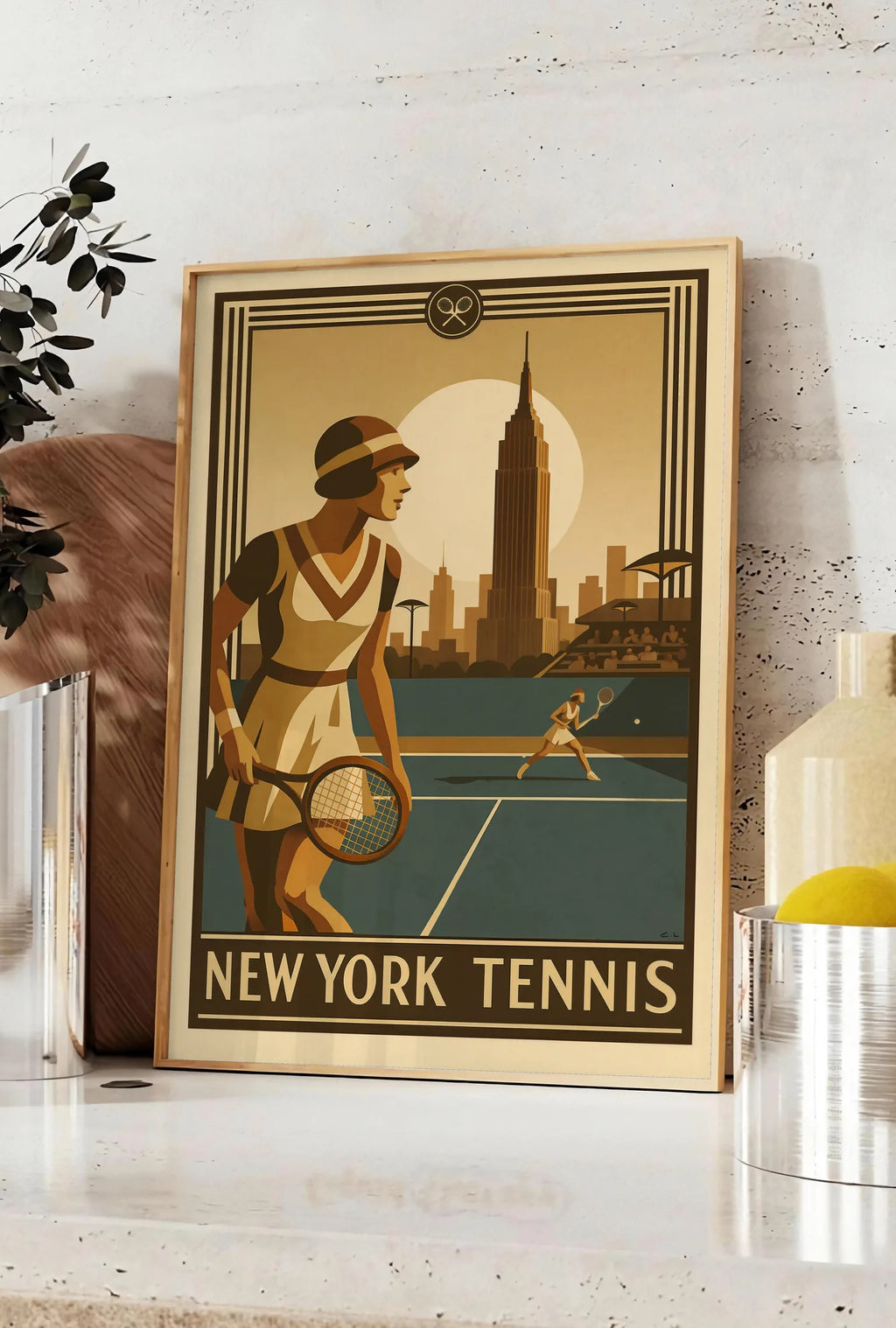 Affiche joueuse de tennis 1920 et raquette en bois, posee sur un plan de travail de cuisine en pierre claire, entre une branche d'eucalyptus en vase et un bocal de citrons