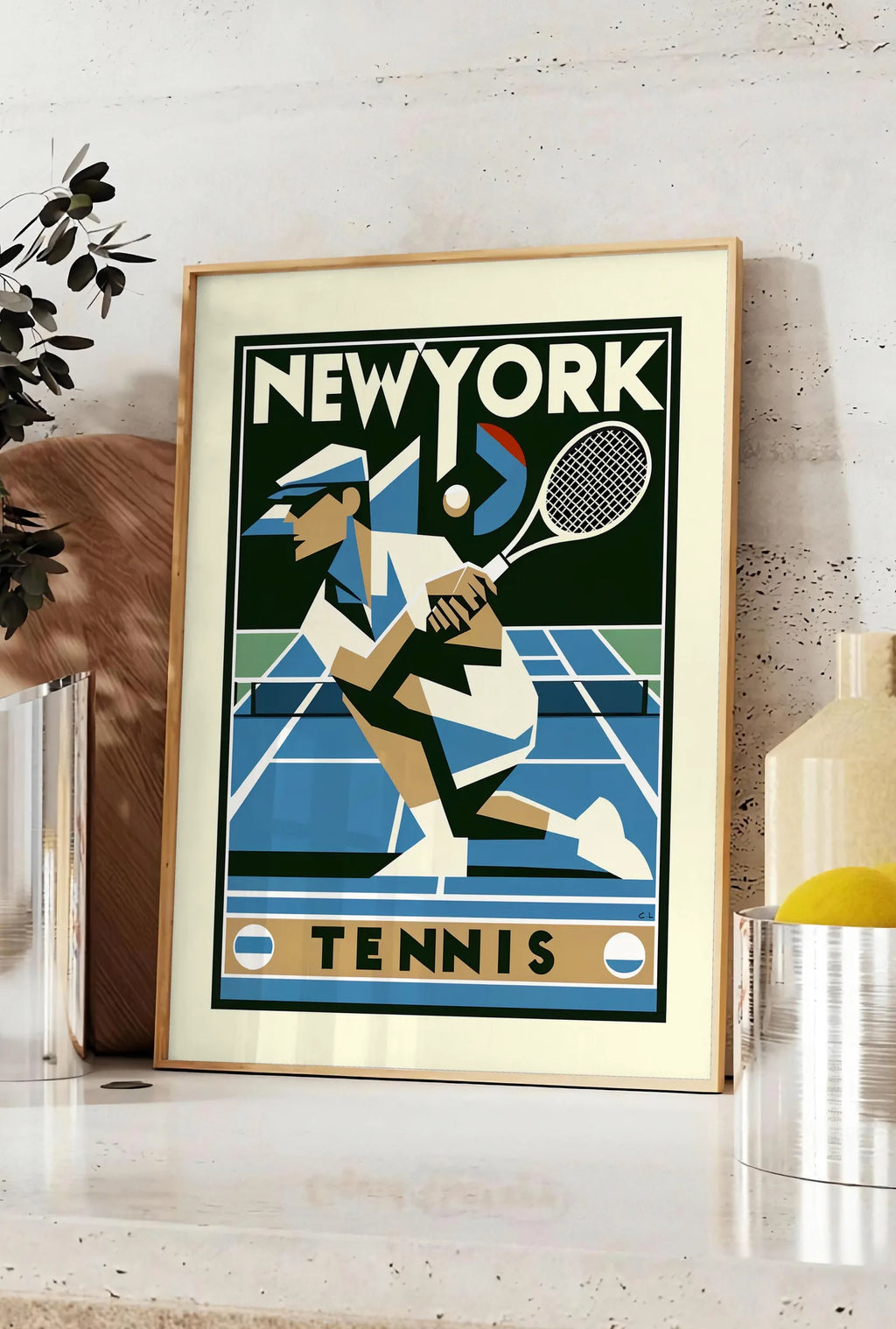 Affiche joueur de tennis cubiste en plein revers, posee sur un plan de travail de cuisine en pierre claire, entre une branche d'eucalyptus en vase et un bocal de citrons