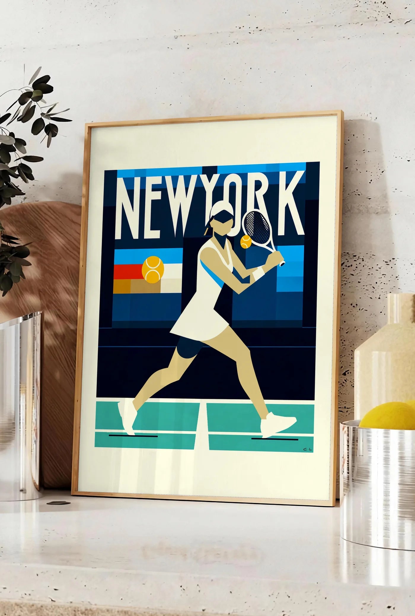 Affiche affiche tennis New York, posee sur un plan de travail de cuisine en pierre claire, entre une branche d'eucalyptus en vase et un bocal de citrons