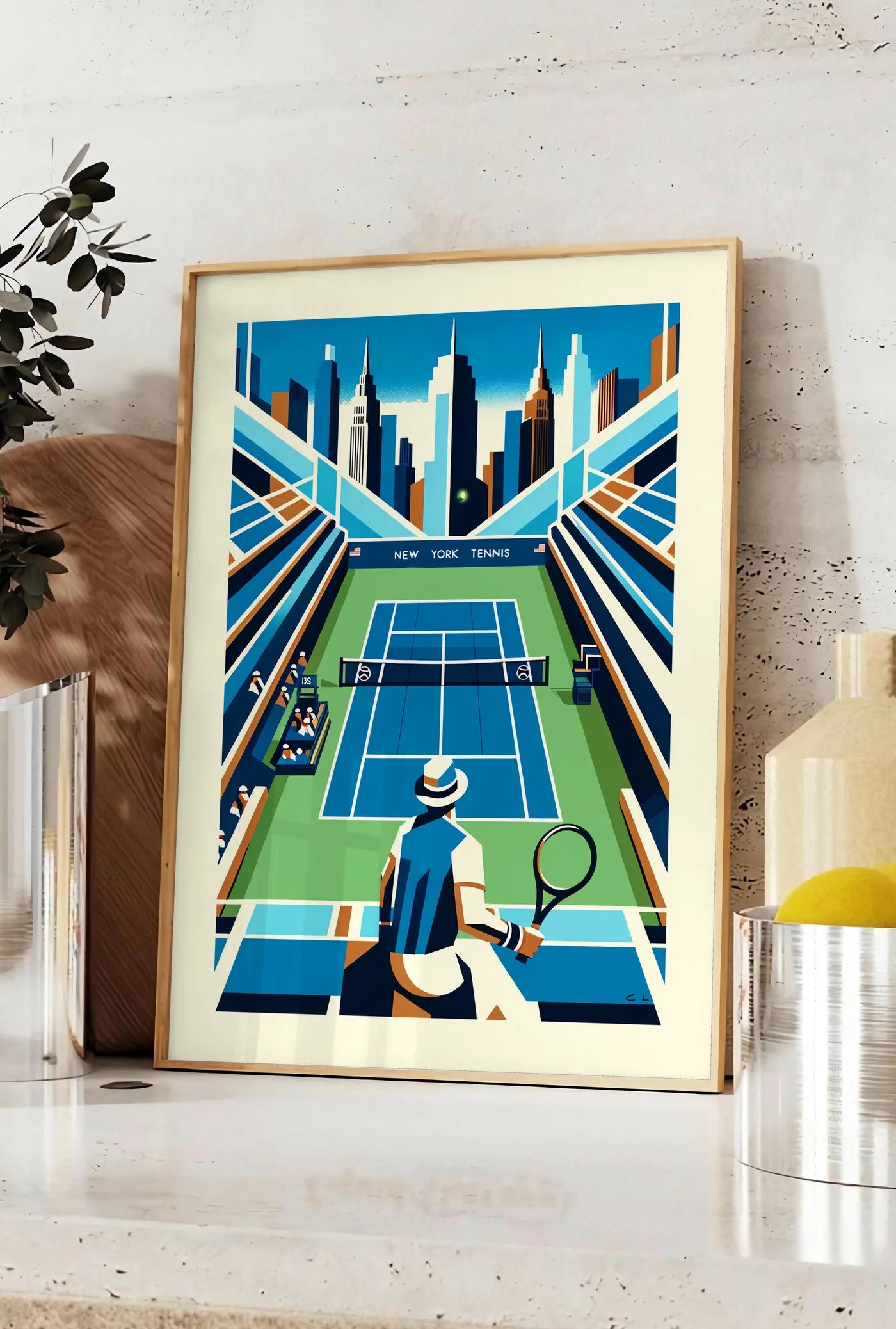 Affiche court de tennis de stade et joueur, posee sur un plan de travail de cuisine en pierre claire, entre une branche d'eucalyptus en vase et un bocal de citrons
