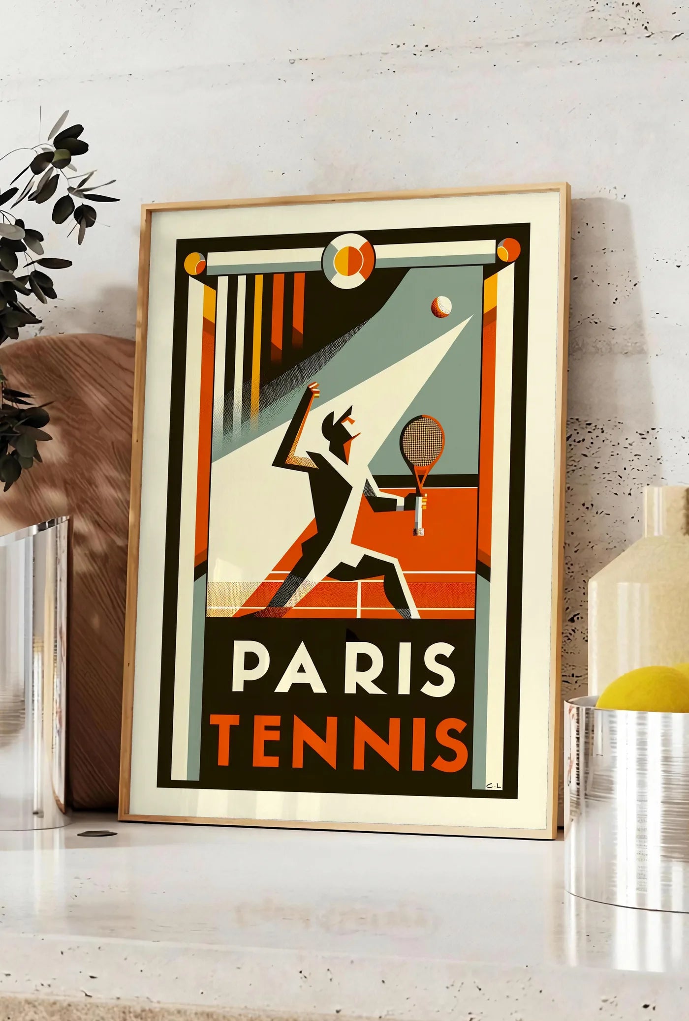 Affiche affiche tennis Paris Art Deco, posee sur un plan de travail de cuisine en pierre claire, entre une branche d'eucalyptus en vase et un bocal de citrons