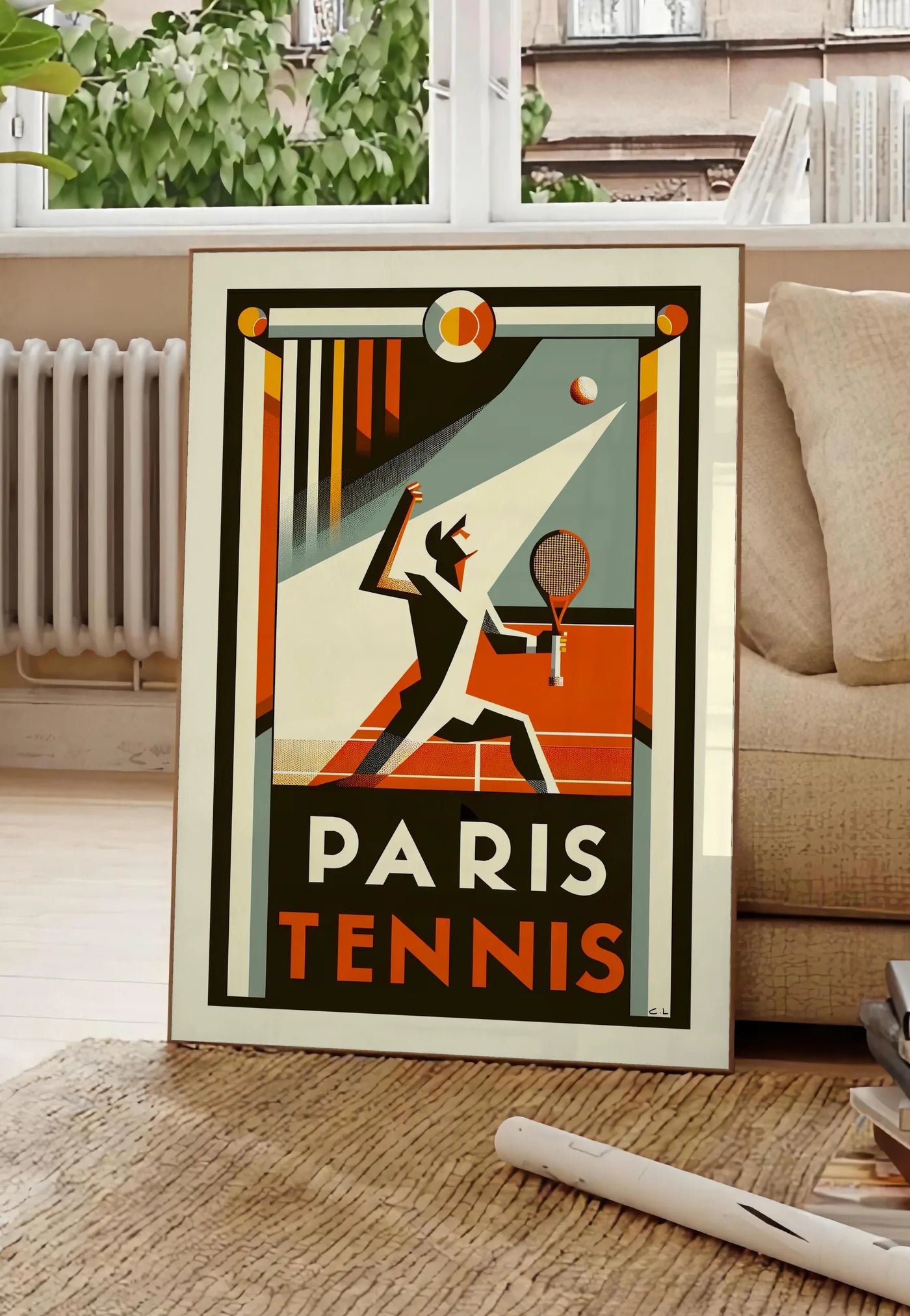 Poster affiche tennis Paris Art Deco, posee au sol dans un salon parisien, devant une grande fenetre donnant sur un immeuble haussmannien, entre un ficus et un canape creme