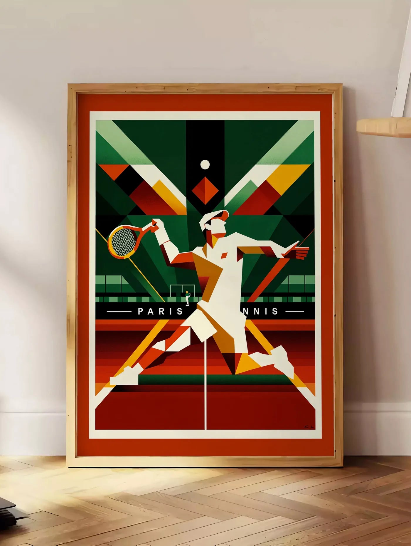 Estampe joueur de tennis cubiste a la raquette, posee au sol dans un coin salon, sur un parquet a chevrons, pres d'une table d'appoint en chene chargee de livres