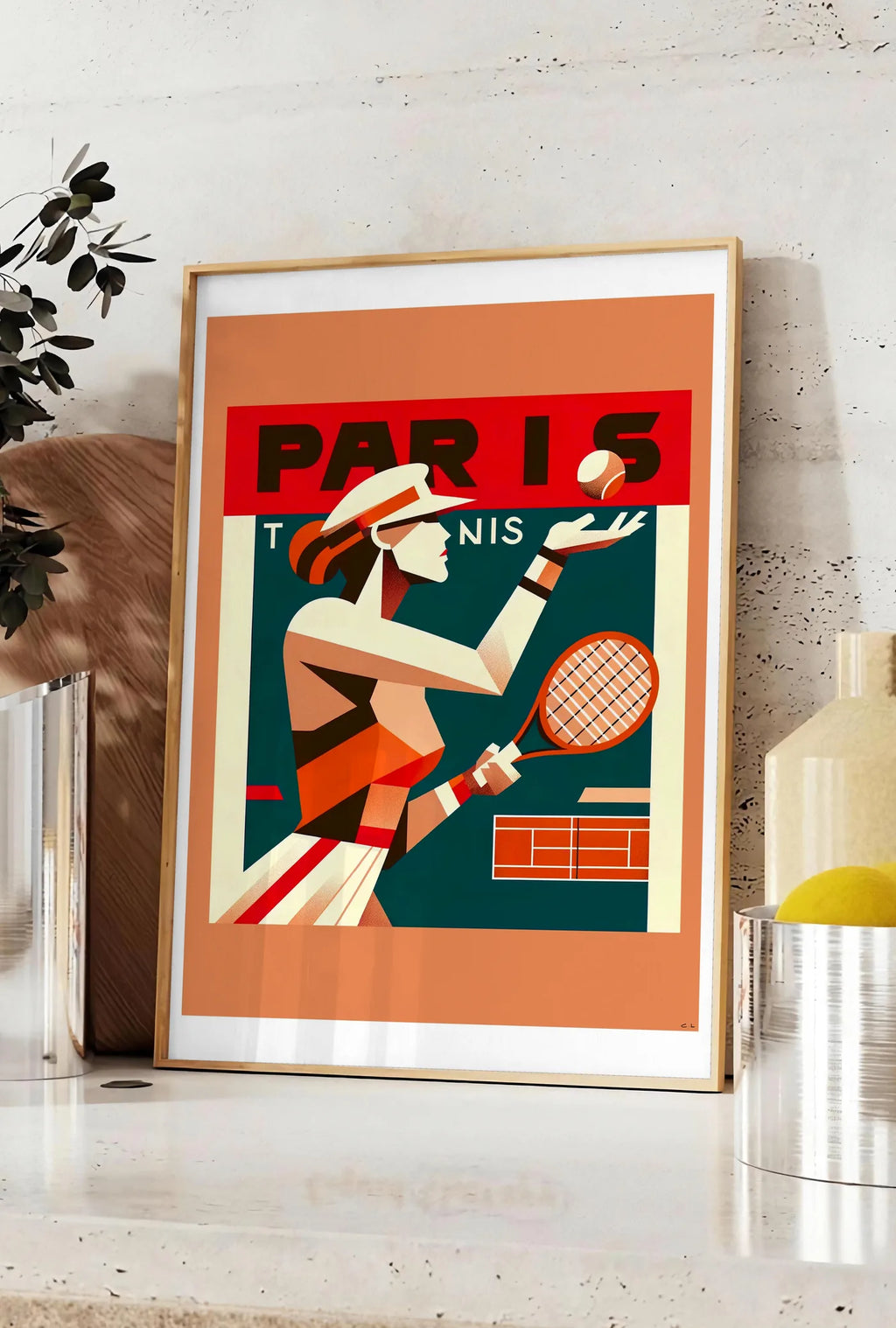 Affiche affiche tennis Paris cubiste, posee sur un plan de travail de cuisine en pierre claire, entre une branche d'eucalyptus en vase et un bocal de citrons