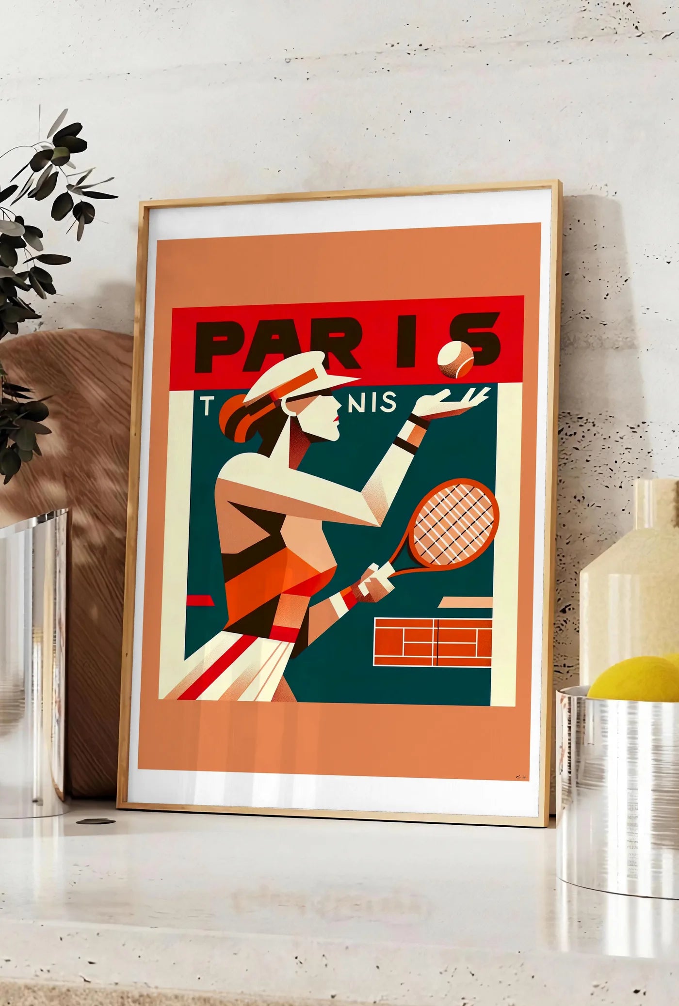 Affiche affiche tennis Paris cubiste, posee sur un plan de travail de cuisine en pierre claire, entre une branche d'eucalyptus en vase et un bocal de citrons
