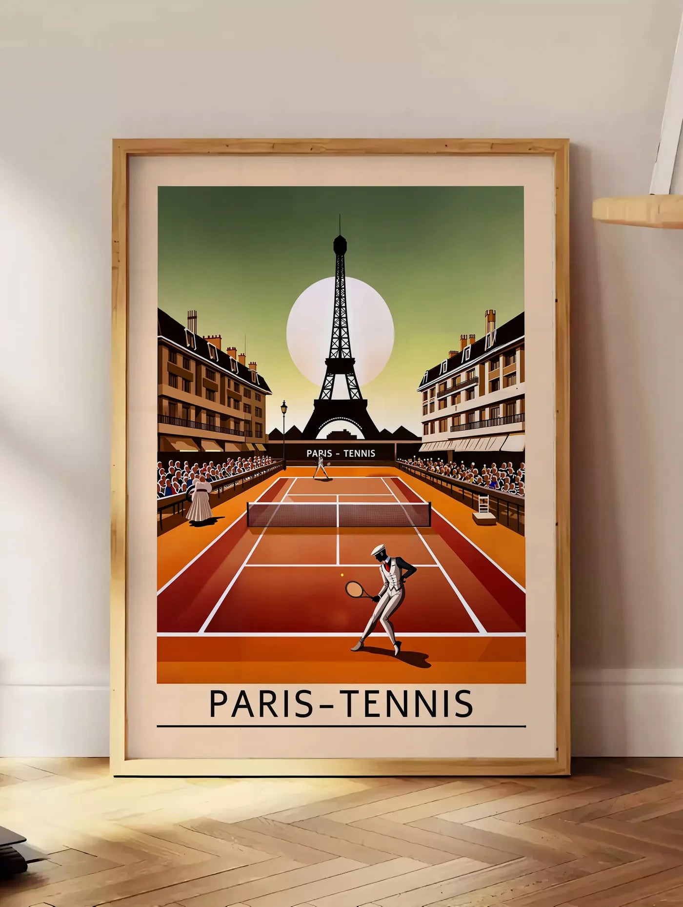 Estampe joueur de tennis sur terre battue, posee au sol dans un coin salon, sur un parquet a chevrons, pres d'une table d'appoint en chene chargee de livres