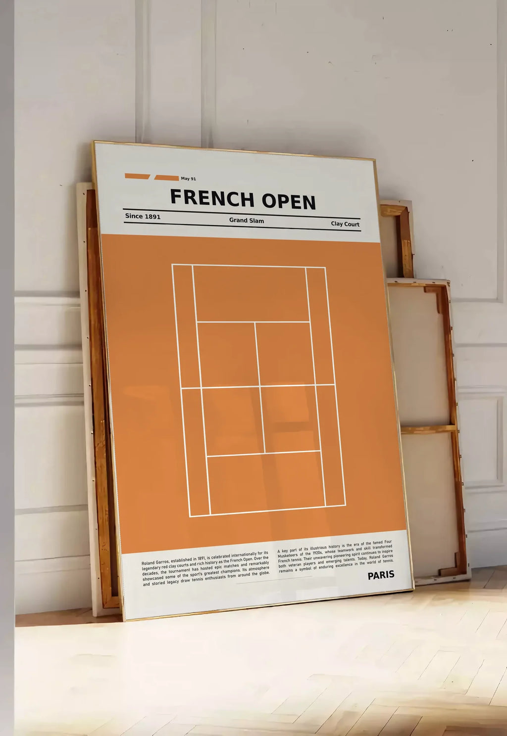 Tirage encadrable court de tennis stylisé en terre battue avec titre FRENCH OPEN, posee au sol dans une entree lumineuse, contre un mur a panneaux blancs, a cote de chassis en bois empiles