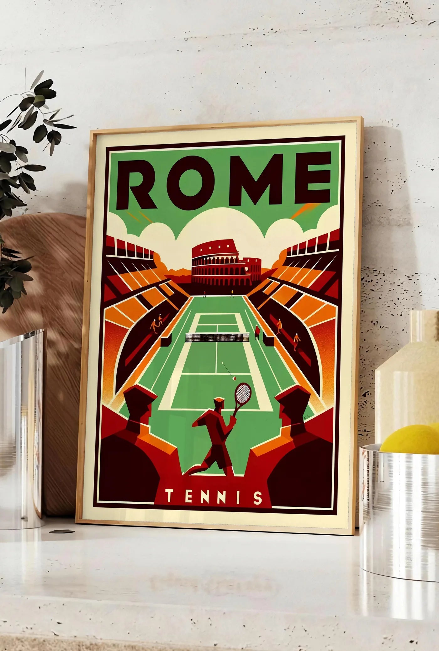 Affiche joueur de tennis et court vert devant le Colisee, posee sur un plan de travail de cuisine en pierre claire, entre une branche d'eucalyptus en vase et un bocal de citrons