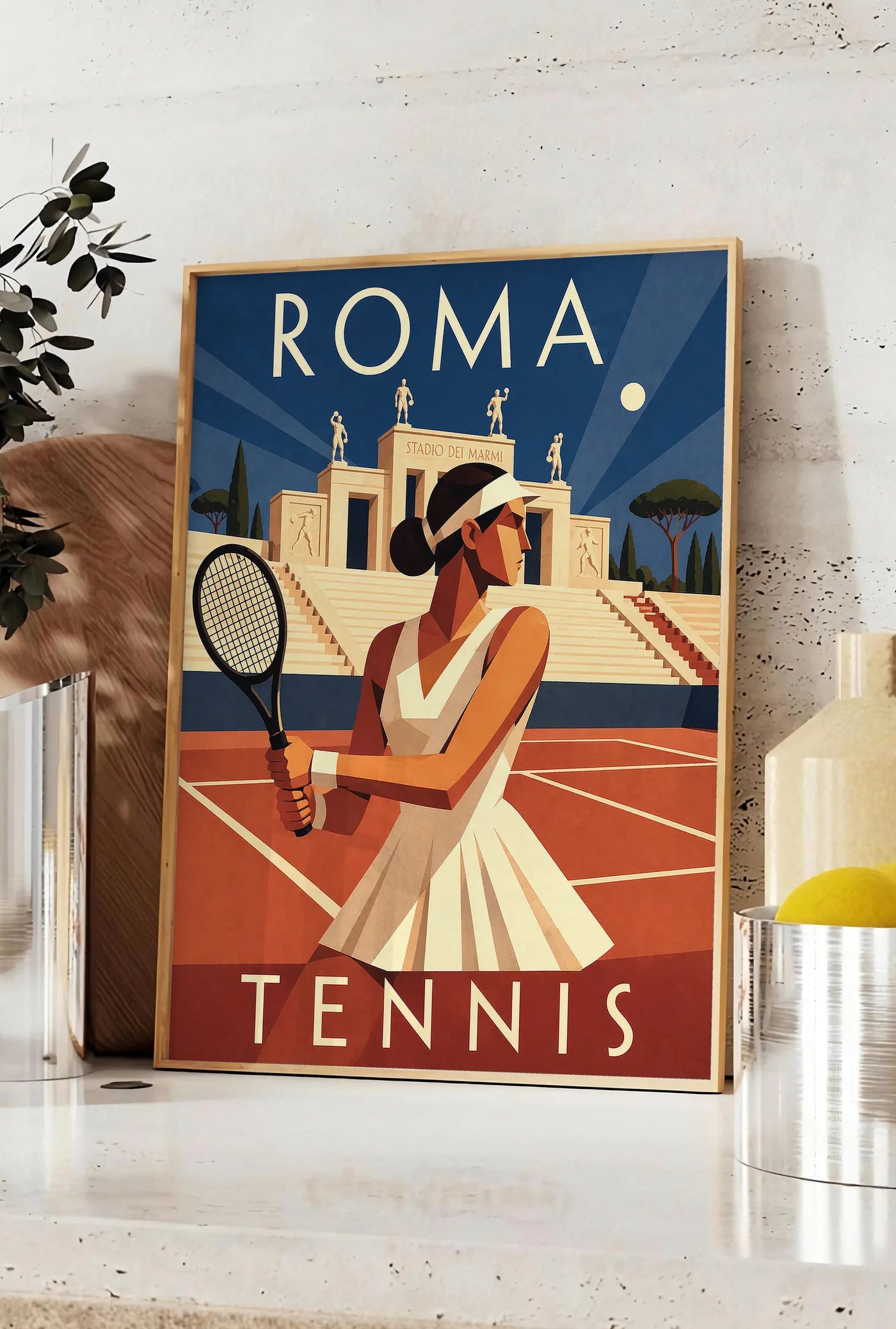 Affiche affiche tennis Rome nuit Art Deco, posee sur un plan de travail de cuisine en pierre claire, entre une branche d'eucalyptus en vase et un bocal de citrons