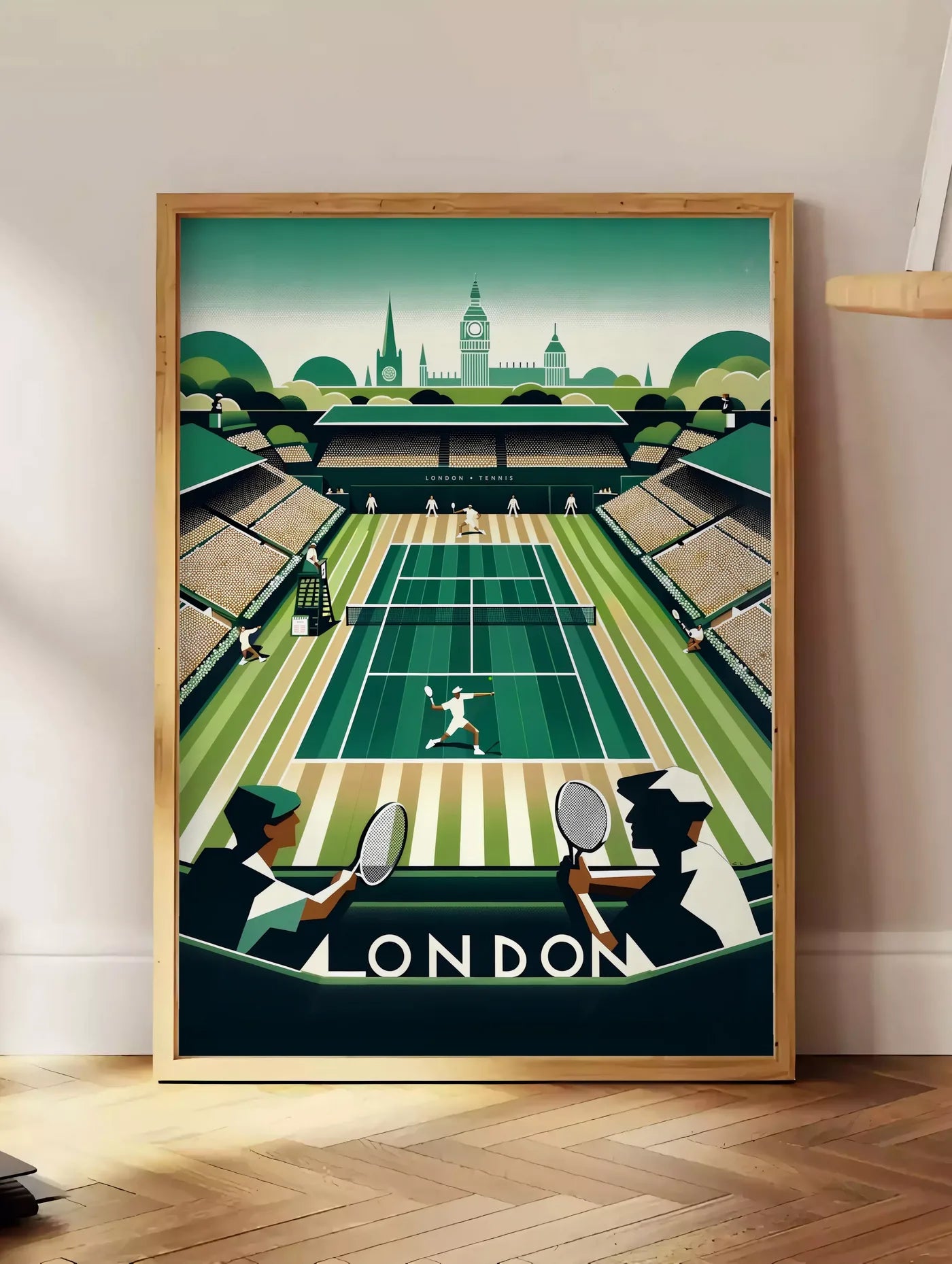 Estampe match de tennis sur un court en gazon vu depuis des spectateurs, posee au sol dans un coin salon, sur un parquet a chevrons, pres d'une table d'appoint en chene chargee de livres