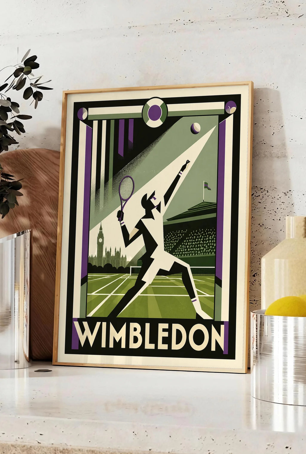 Affiche affiche Wimbledon Art Deco, posee sur un plan de travail de cuisine en pierre claire, entre une branche d'eucalyptus en vase et un bocal de citrons