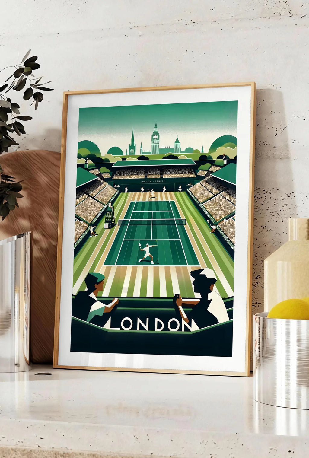 Affiche court de tennis en gazon et spectateurs, posee sur un plan de travail de cuisine en pierre claire, entre une branche d'eucalyptus en vase et un bocal de citrons