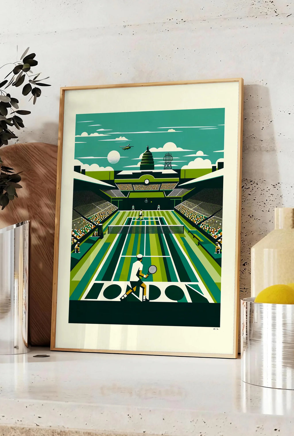 Affiche joueur de tennis de dos sur gazon raye, posee sur un plan de travail de cuisine en pierre claire, entre une branche d'eucalyptus en vase et un bocal de citrons