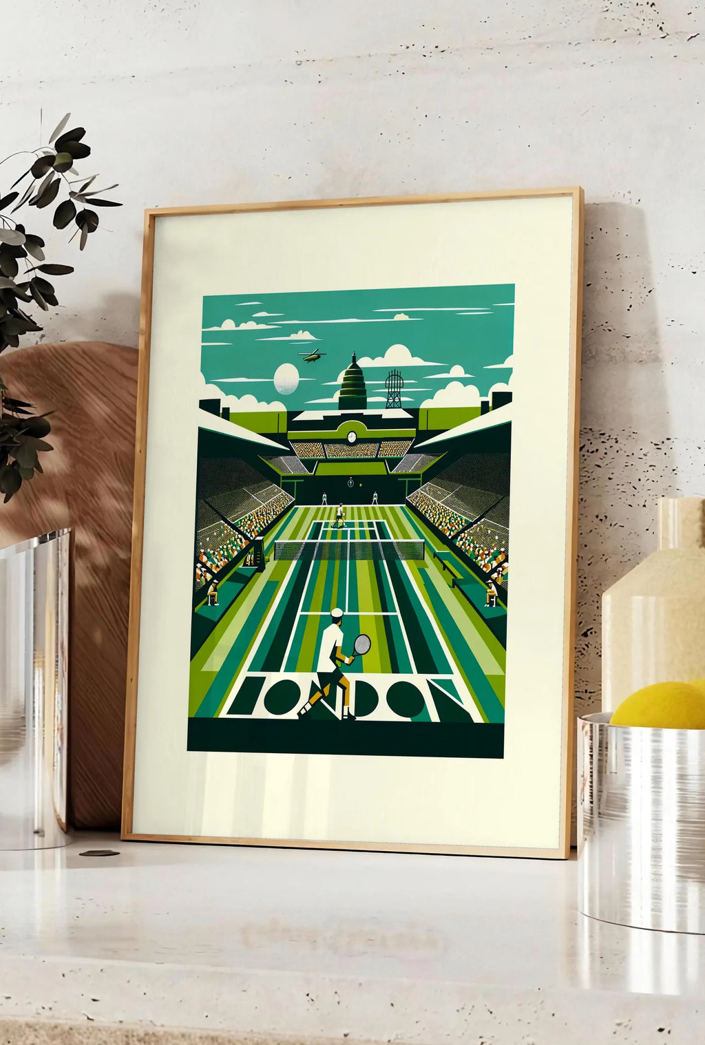 Affiche joueur de tennis de dos sur gazon de stade, posee sur un plan de travail de cuisine en pierre claire, entre une branche d'eucalyptus en vase et un bocal de citrons