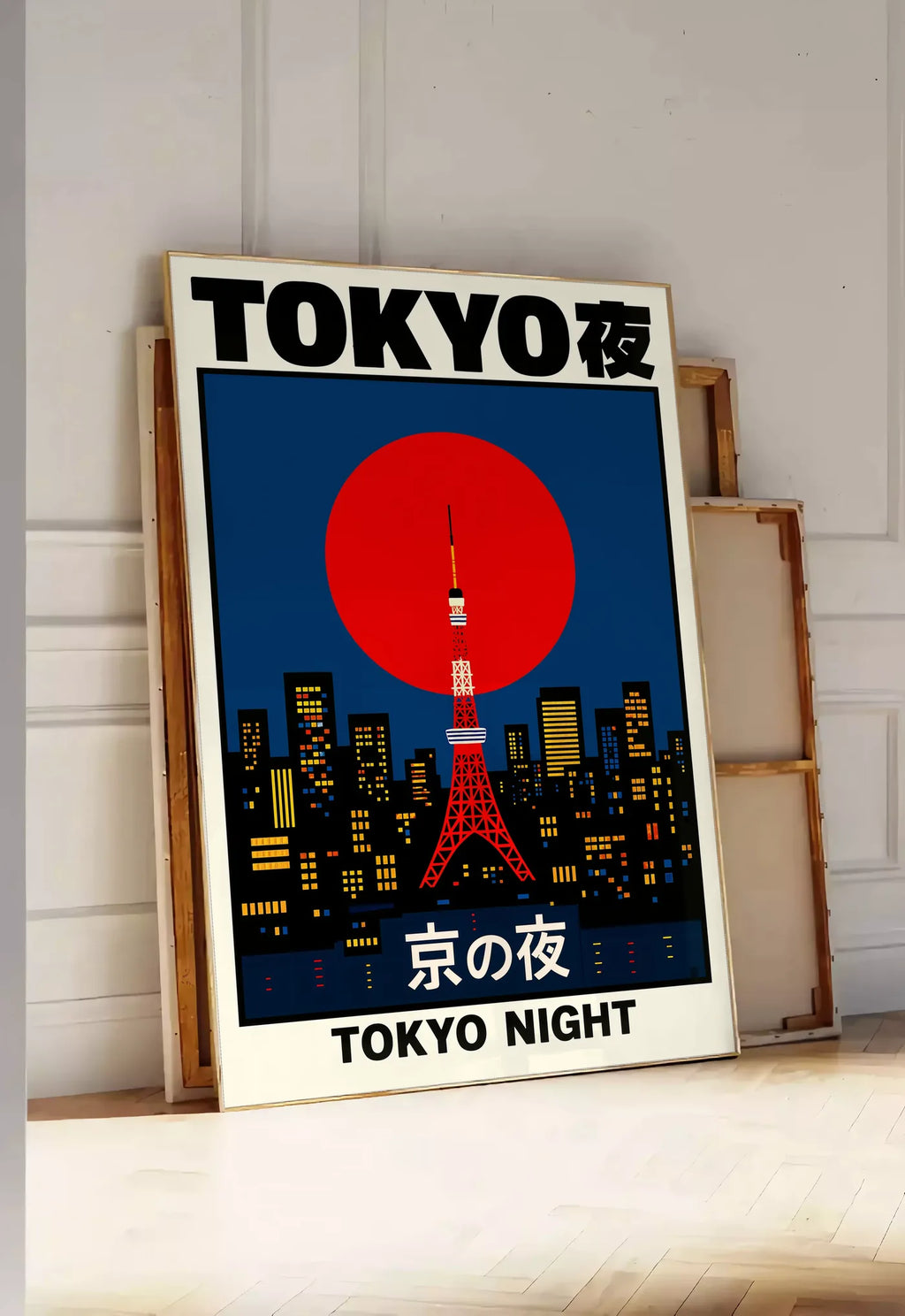 Tirage encadrable affiche tour de Tokyo et soleil rouge art japonais, posee au sol dans une entree lumineuse, contre un mur a panneaux blancs, a cote de chassis en bois empiles