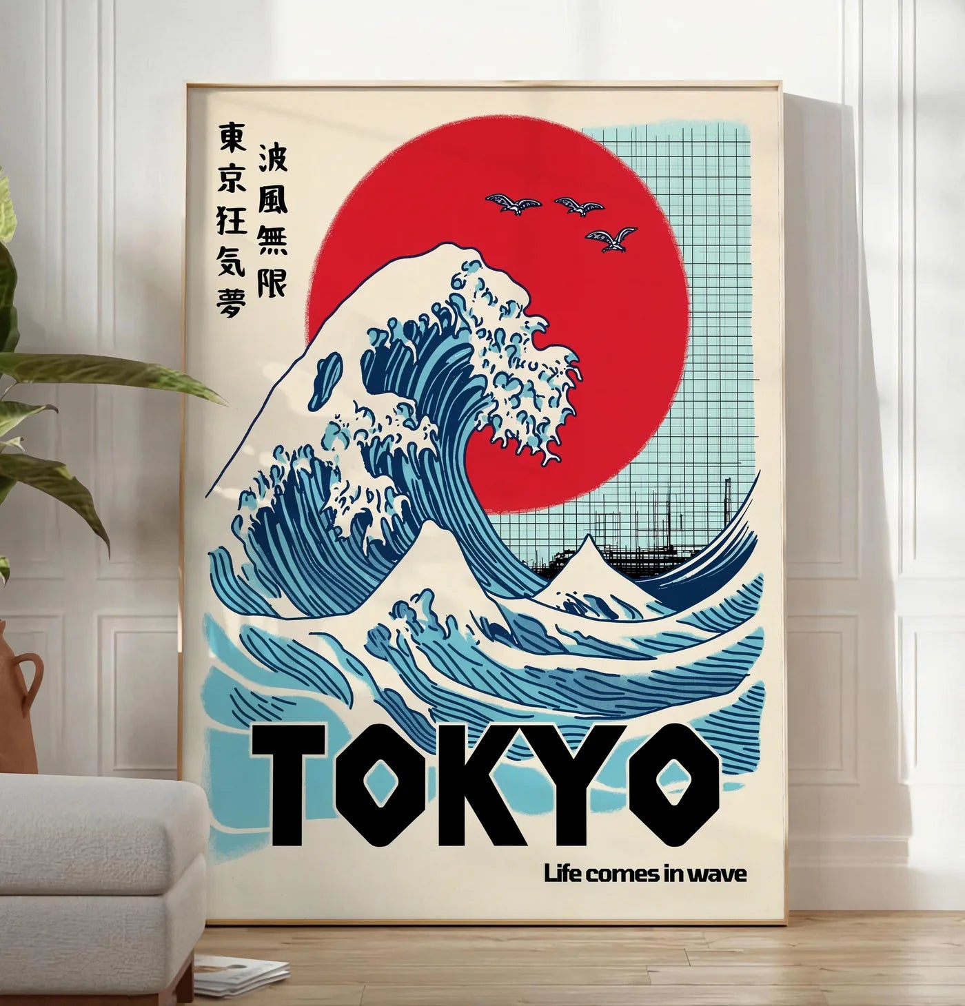 Reproduction affiche vague de Tokyo et soleil rouge art japonais, posee au sol dans un salon minimaliste clair, a cote d'un canape beige et d'une plante verte, sur un parquet clair