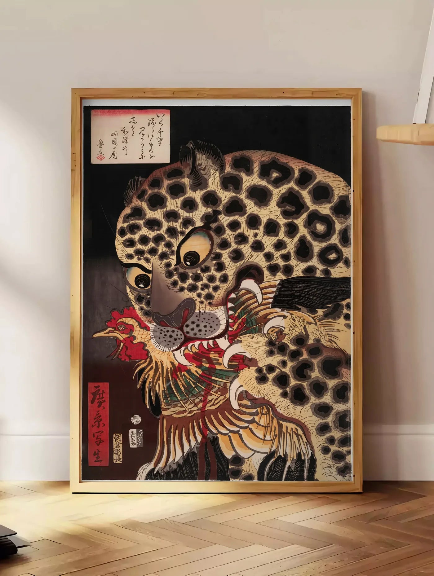 Estampe affiche tigre de Ryokoku d Utagawa Hirokage, posee au sol dans un coin salon, sur un parquet a chevrons, pres d'une table d'appoint en chene chargee de livres