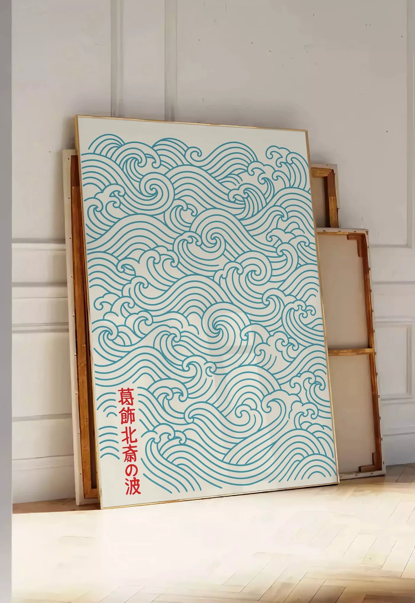Tirage encadrable affiche vagues japonaises motif seigaiha au trait bleu sarcelle sur creme, posee au sol dans une entree lumineuse, contre un mur a panneaux blancs, a cote de chassis en bois empiles