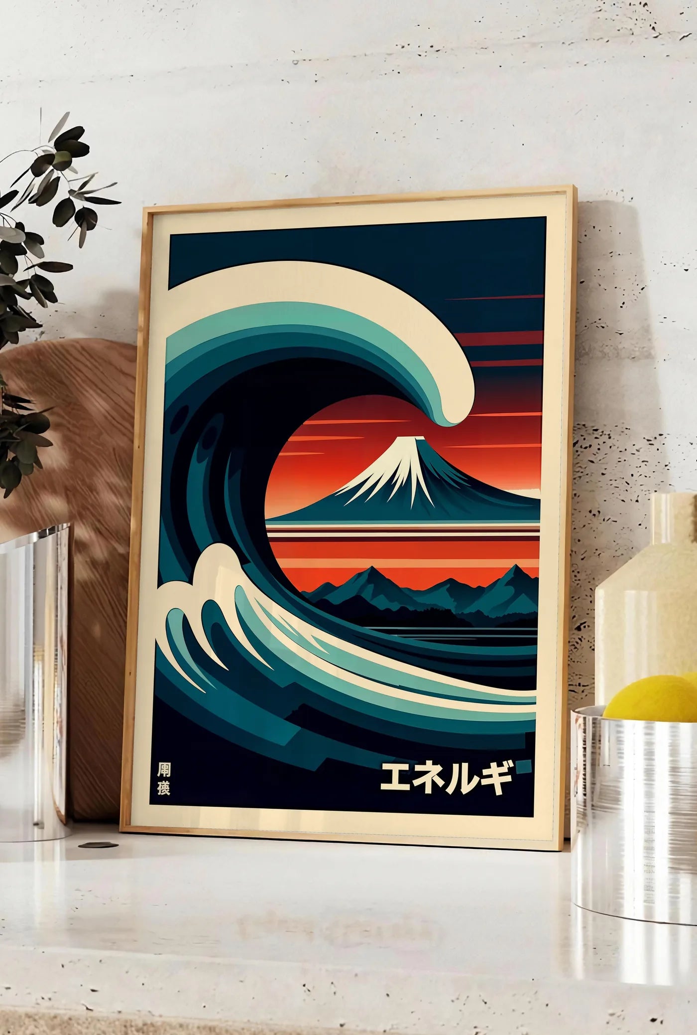 Affiche affiche vague stylisee devant le mont Fuji au soleil couchant japon, posee sur un plan de travail de cuisine en pierre claire, entre une branche d'eucalyptus en vase et un bocal de citrons