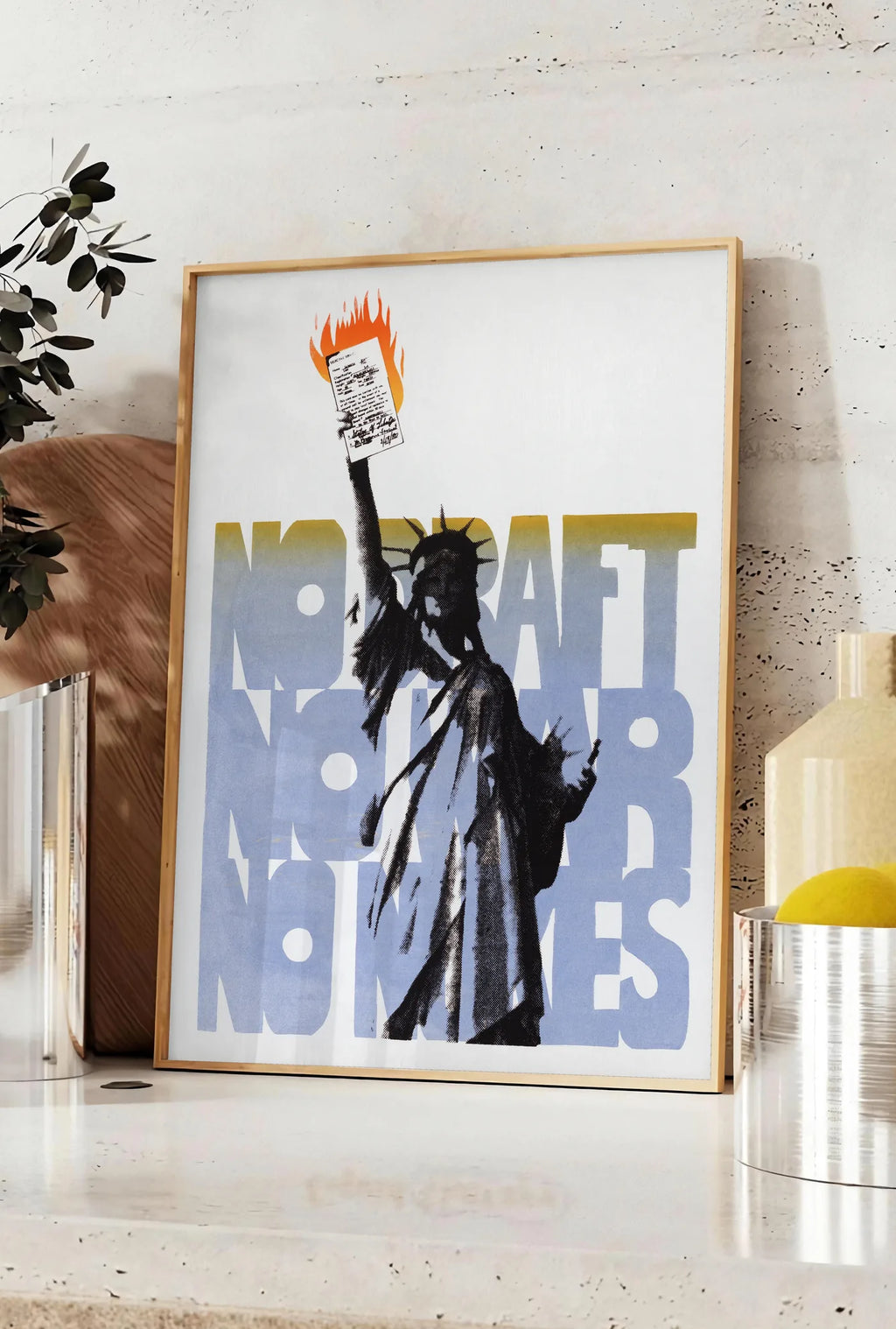 Affiche affiche Statue de la Liberte vintage, posee sur un plan de travail de cuisine en pierre claire, entre une branche d'eucalyptus en vase et un bocal de citrons