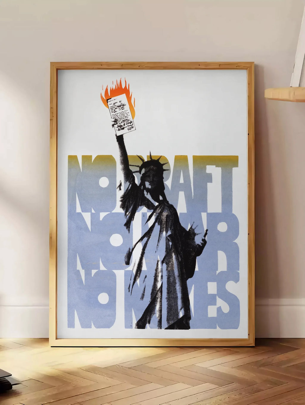 Estampe affiche Statue de la Liberte vintage, posee au sol dans un coin salon, sur un parquet a chevrons, pres d'une table d'appoint en chene chargee de livres