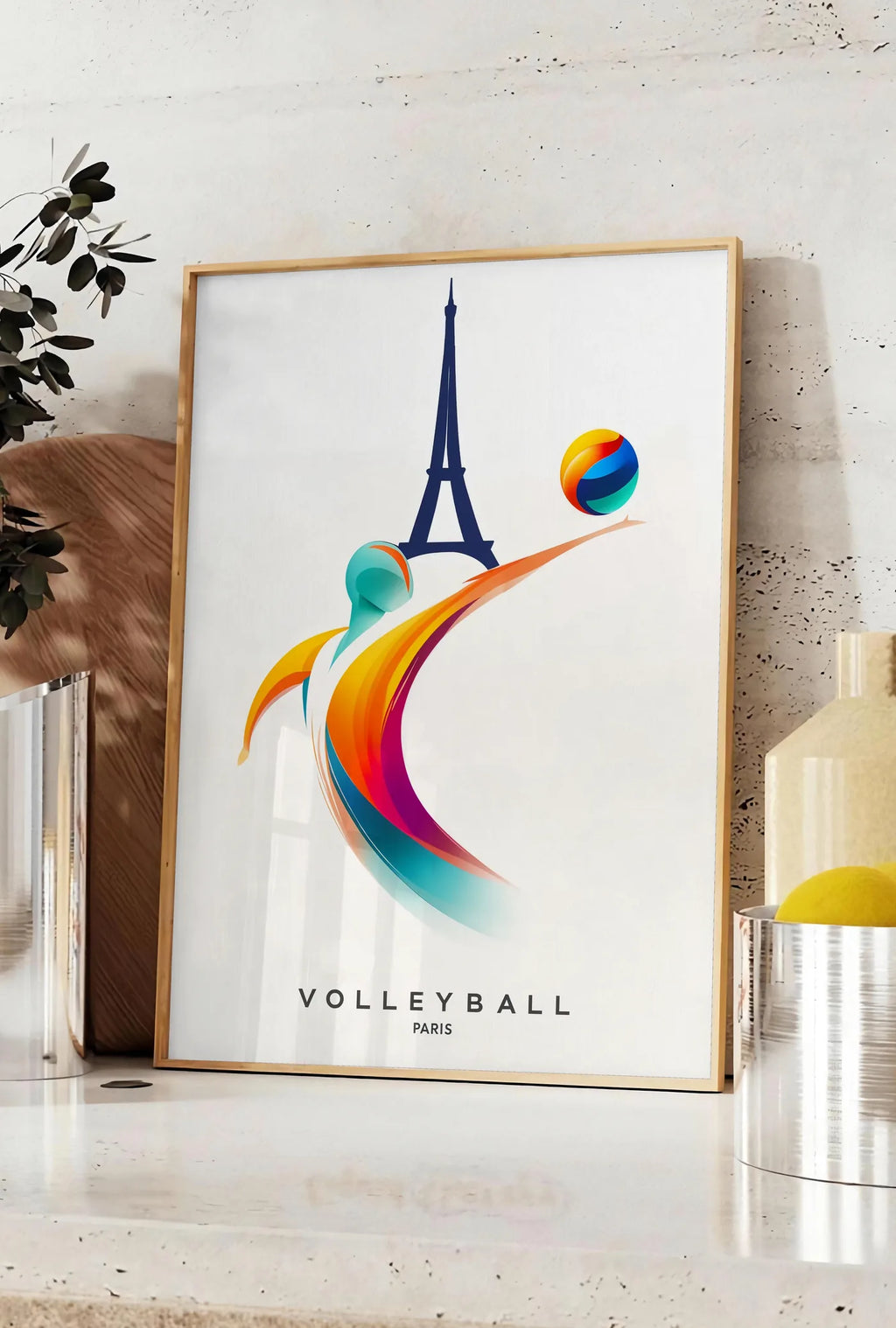 Affiche affiche volleyball Paris, posee sur un plan de travail de cuisine en pierre claire, entre une branche d'eucalyptus en vase et un bocal de citrons