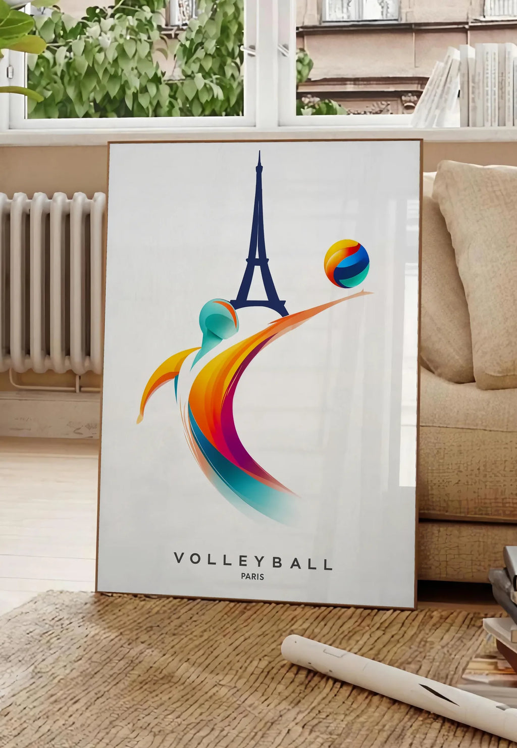 Poster affiche volleyball Paris, posee au sol dans un salon parisien, devant une grande fenetre donnant sur un immeuble haussmannien, entre un ficus et un canape creme