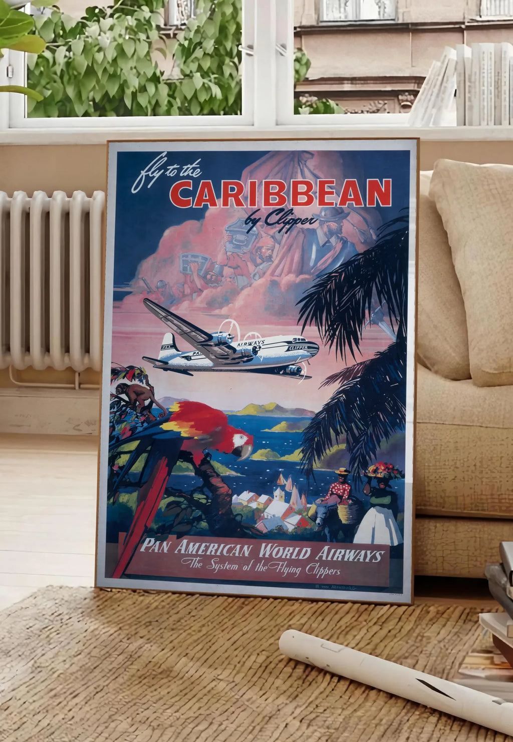 Poster affiche Caraibes vintage, posee au sol dans un salon parisien, devant une grande fenetre donnant sur un immeuble haussmannien, entre un ficus et un canape creme
