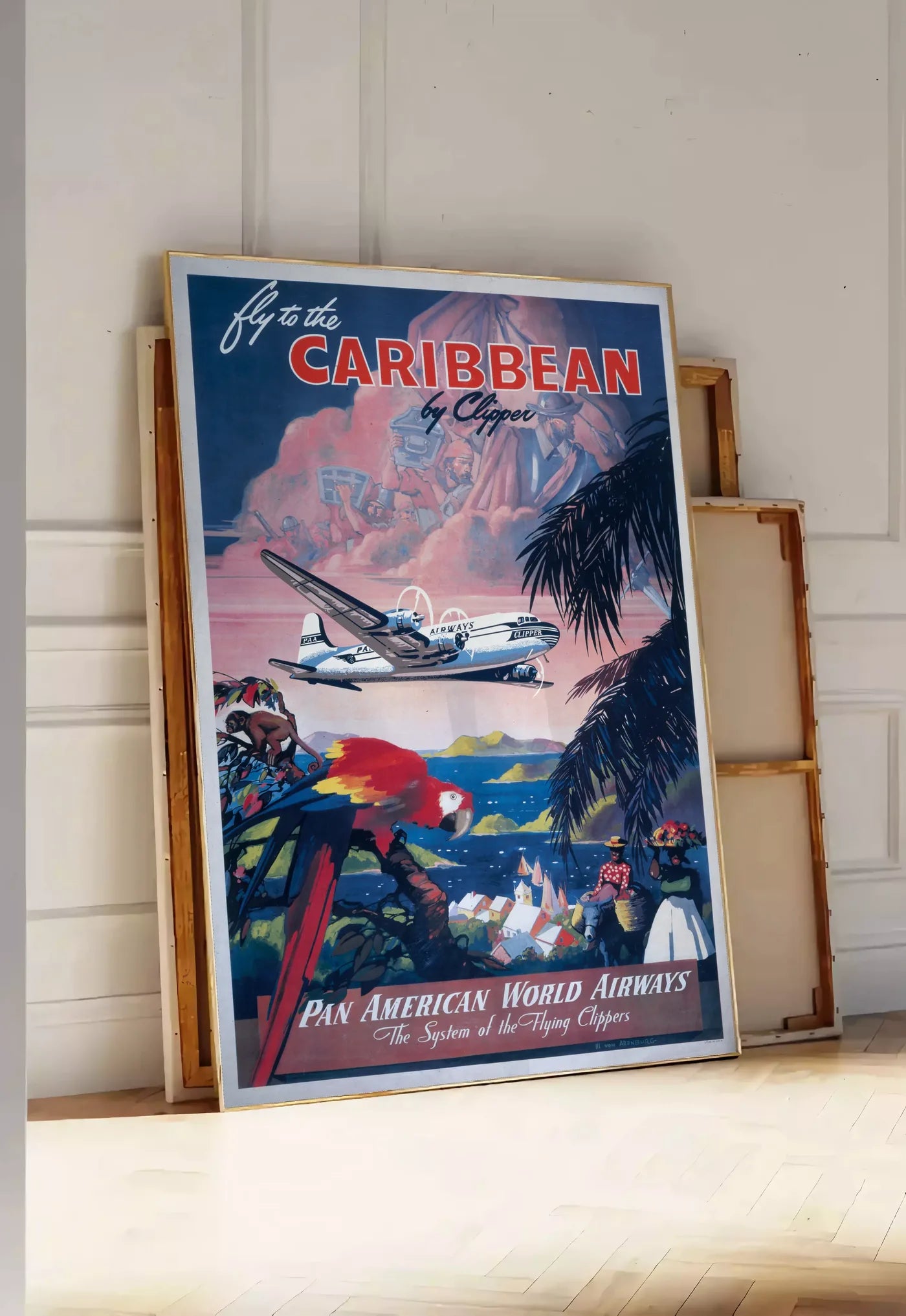 Tirage encadrable affiche Caraibes vintage, posee au sol dans une entree lumineuse, contre un mur a panneaux blancs, a cote de chassis en bois empiles