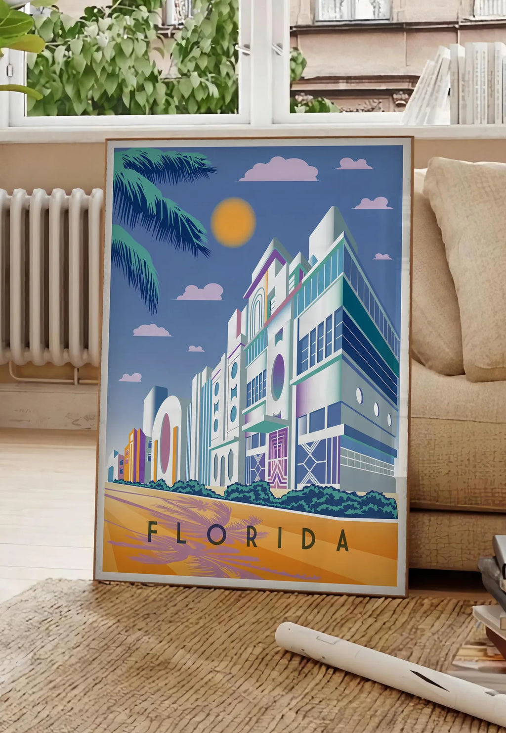 Poster affiche Floride Art Deco, posee au sol dans un salon parisien, devant une grande fenetre donnant sur un immeuble haussmannien, entre un ficus et un canape creme