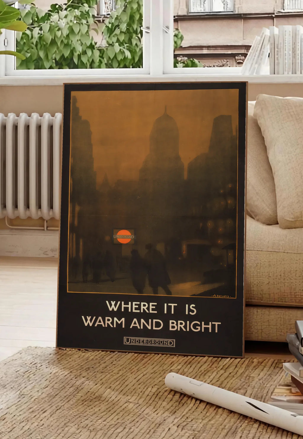 Poster affiche Londres vintage, posee au sol dans un salon parisien, devant une grande fenetre donnant sur un immeuble haussmannien, entre un ficus et un canape creme