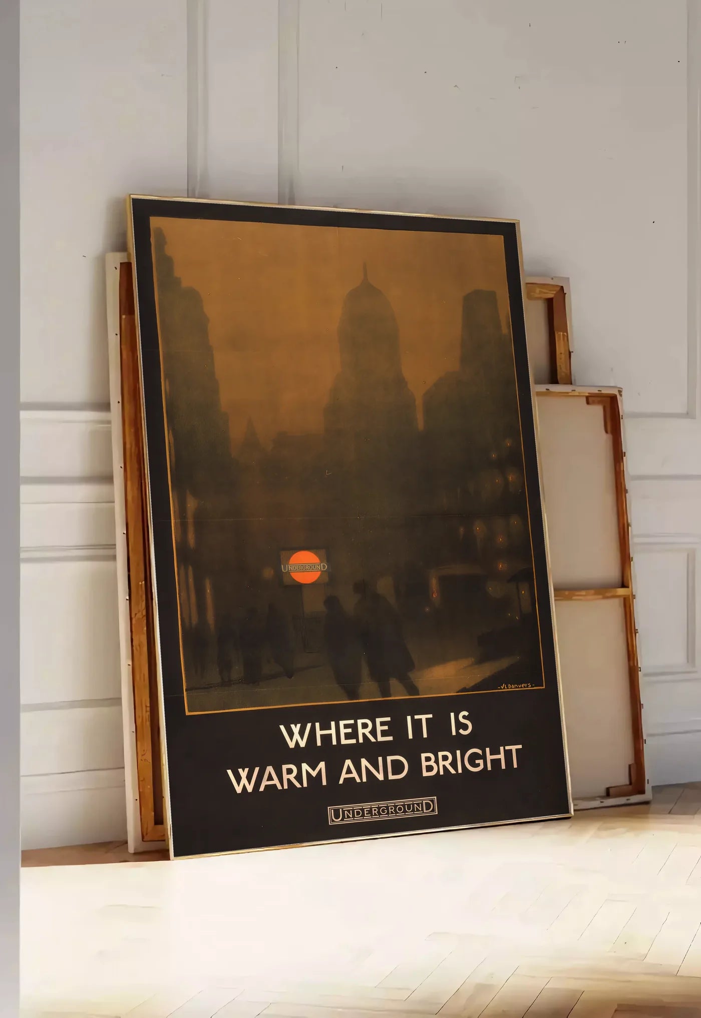 Tirage encadrable affiche Londres vintage, posee au sol dans une entree lumineuse, contre un mur a panneaux blancs, a cote de chassis en bois empiles