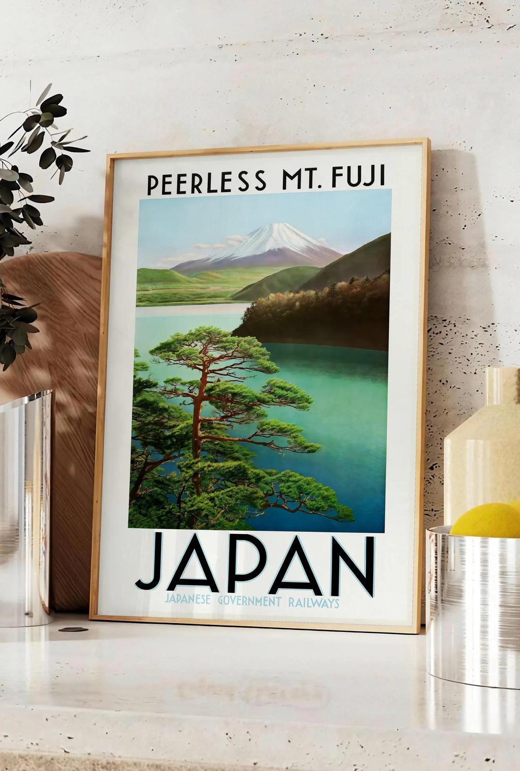 Affiche affiche mont Fuji voyage vintage art japonais, posee sur un plan de travail de cuisine en pierre claire, entre une branche d'eucalyptus en vase et un bocal de citrons