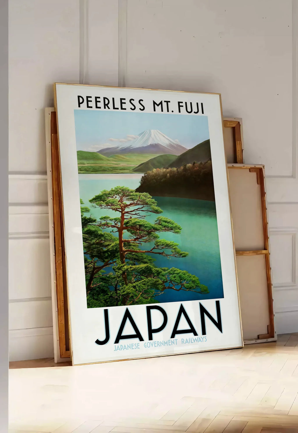 Tirage encadrable affiche mont Fuji voyage vintage art japonais, posee au sol dans une entree lumineuse, contre un mur a panneaux blancs, a cote de chassis en bois empiles