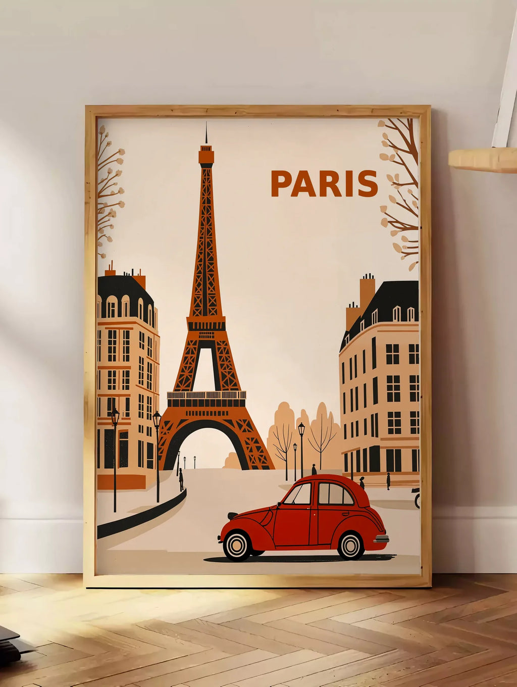 Estampe affiche Paris vintage, posee au sol dans un coin salon, sur un parquet a chevrons, pres d'une table d'appoint en chene chargee de livres