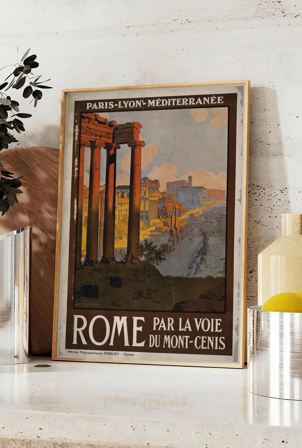 Affiche affiche Rome vintage, posee sur un plan de travail de cuisine en pierre claire, entre une branche d'eucalyptus en vase et un bocal de citrons