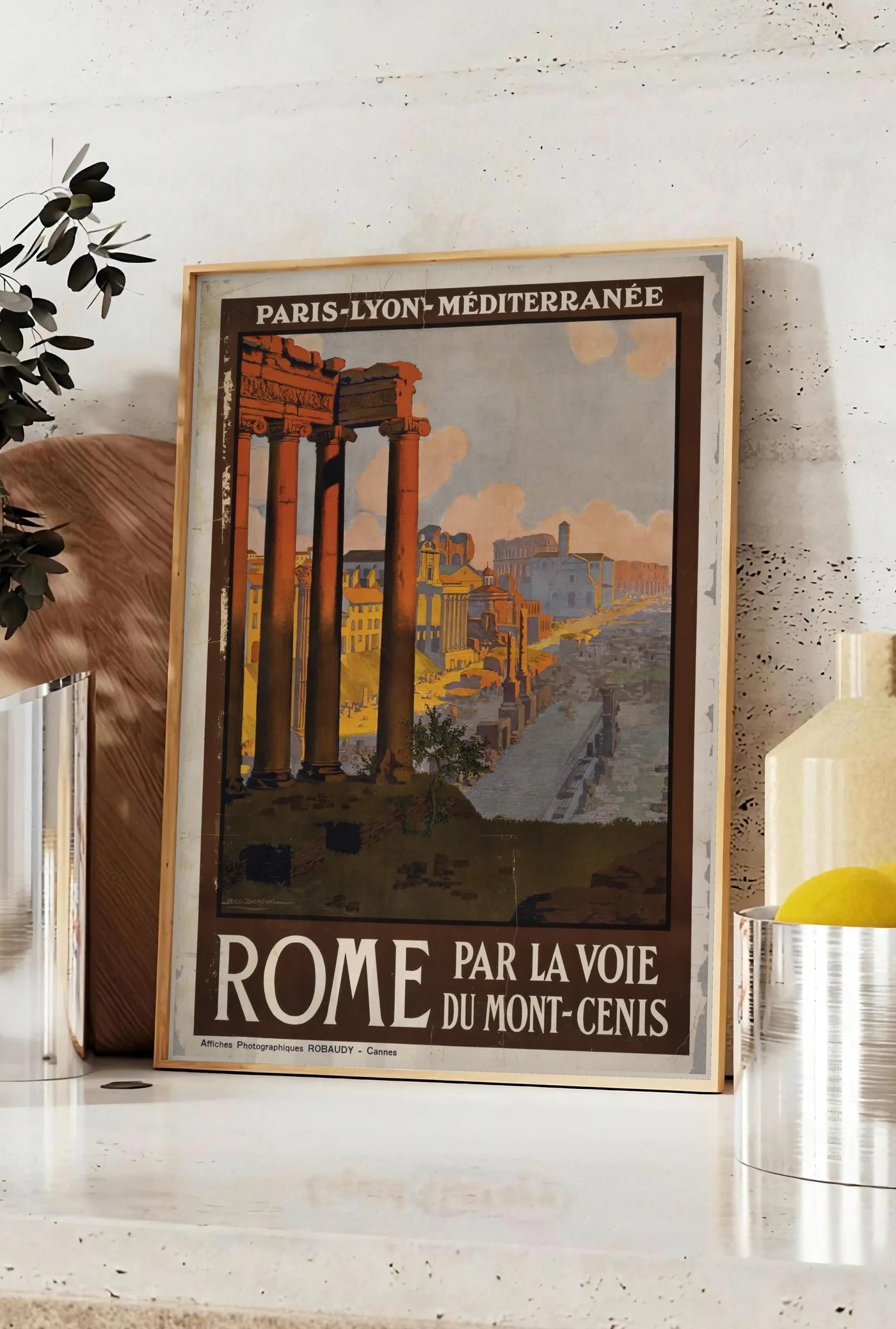 Affiche affiche Rome vintage, posee sur un plan de travail de cuisine en pierre claire, entre une branche d'eucalyptus en vase et un bocal de citrons
