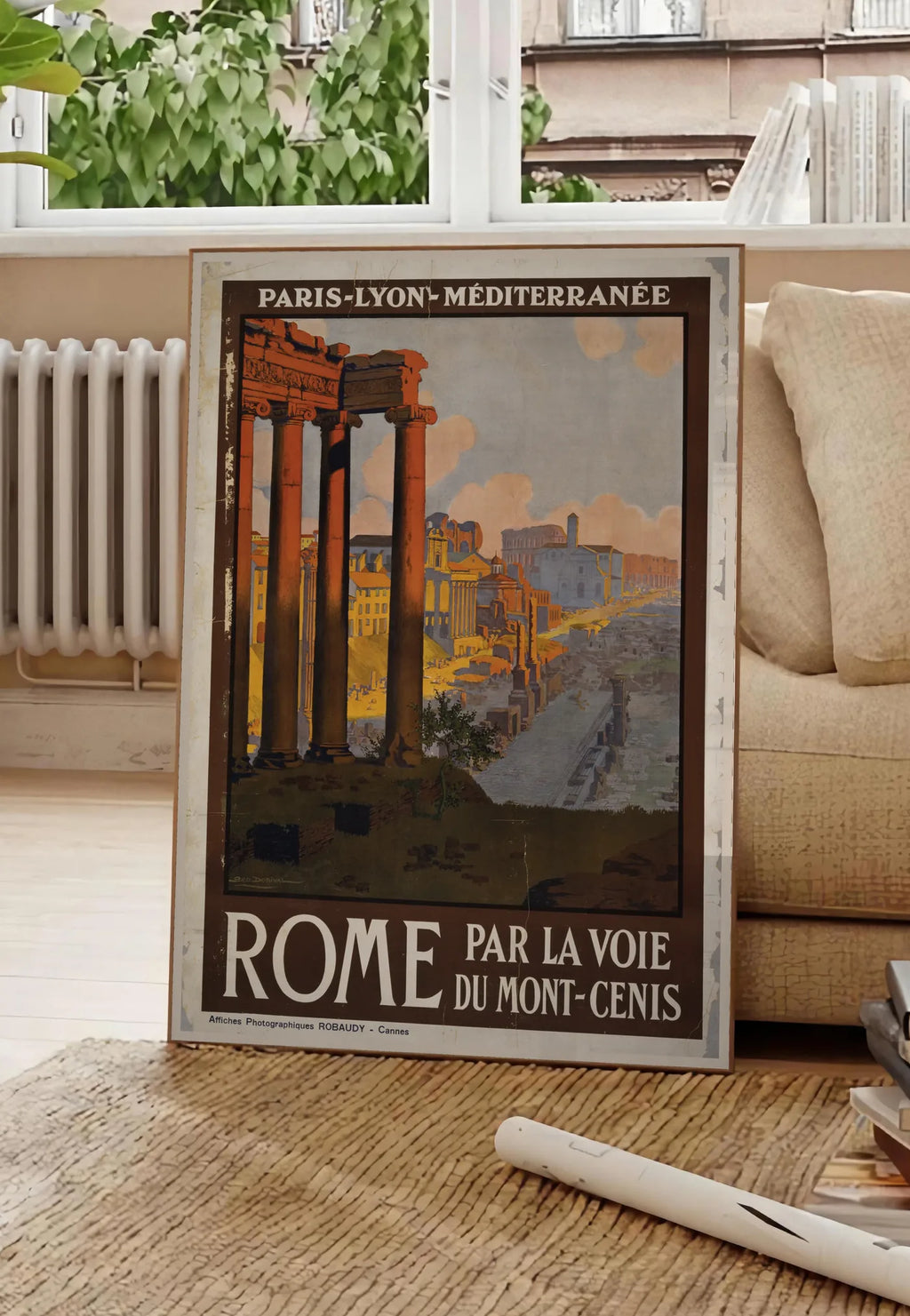 Poster affiche Rome vintage PLM, posee au sol dans un salon parisien, devant une grande fenetre donnant sur un immeuble haussmannien, entre un ficus et un canape creme